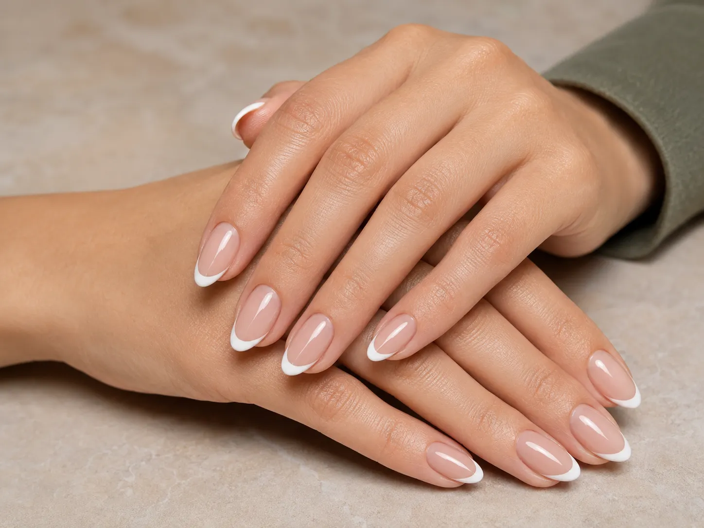 Close-up of almond French tip nails showing the gradual taper and curved tip placement