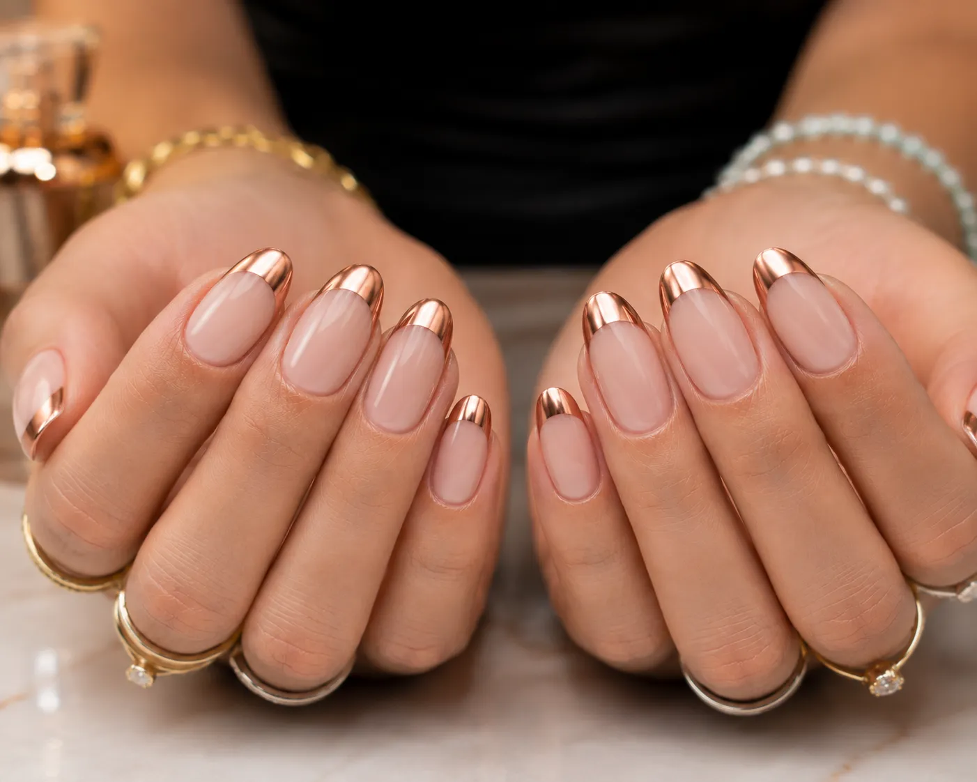 Rose gold chrome French tips over a soft blush base