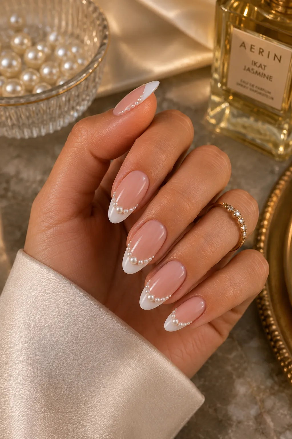Almond pearl French tip nails with restrained dimensional pearl accents