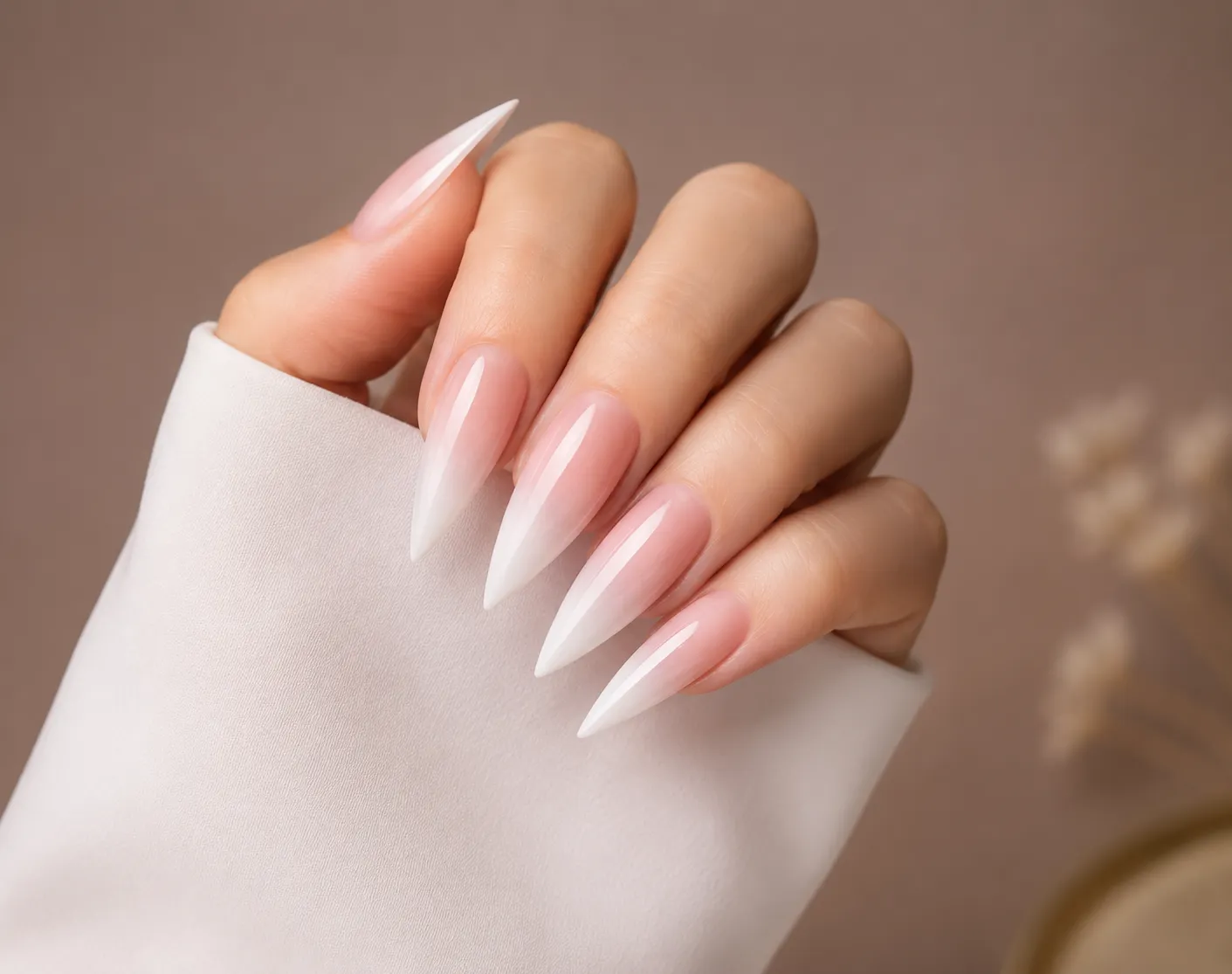 Baby Boomer French fade on long stiletto nails with dramatic pointed silhouette