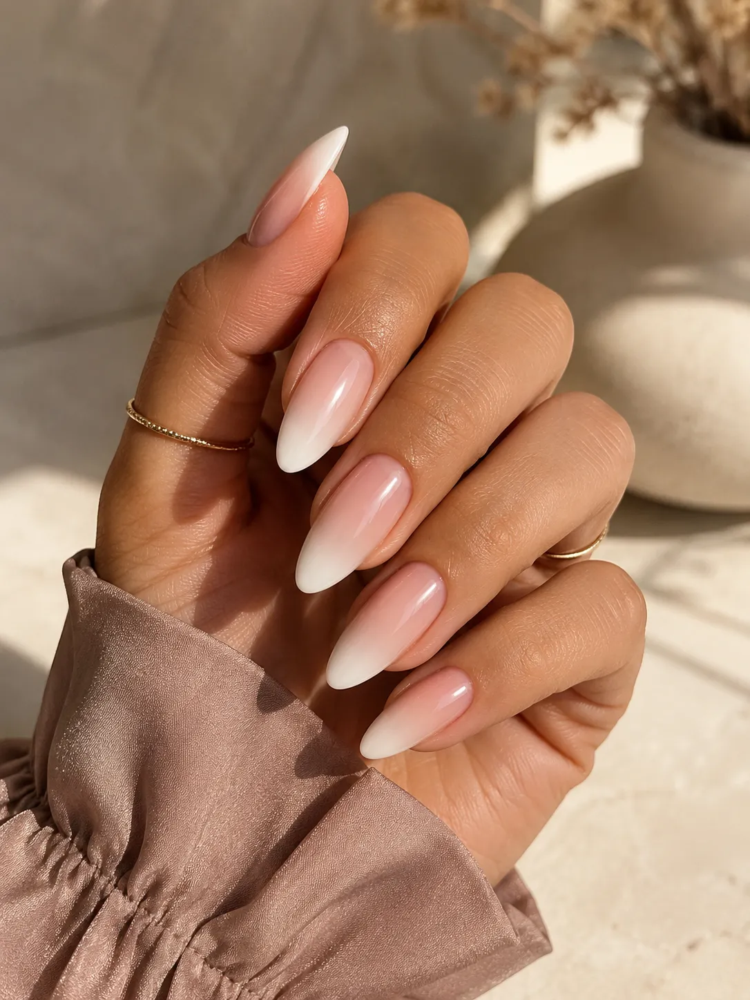 Baby Boomer nails on olive skin with warm nude pink base and creamy white fade