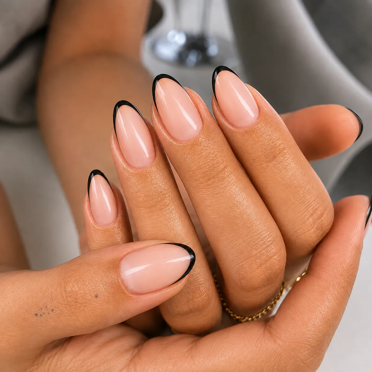 Fine black micro French tips on short glossy nude nails