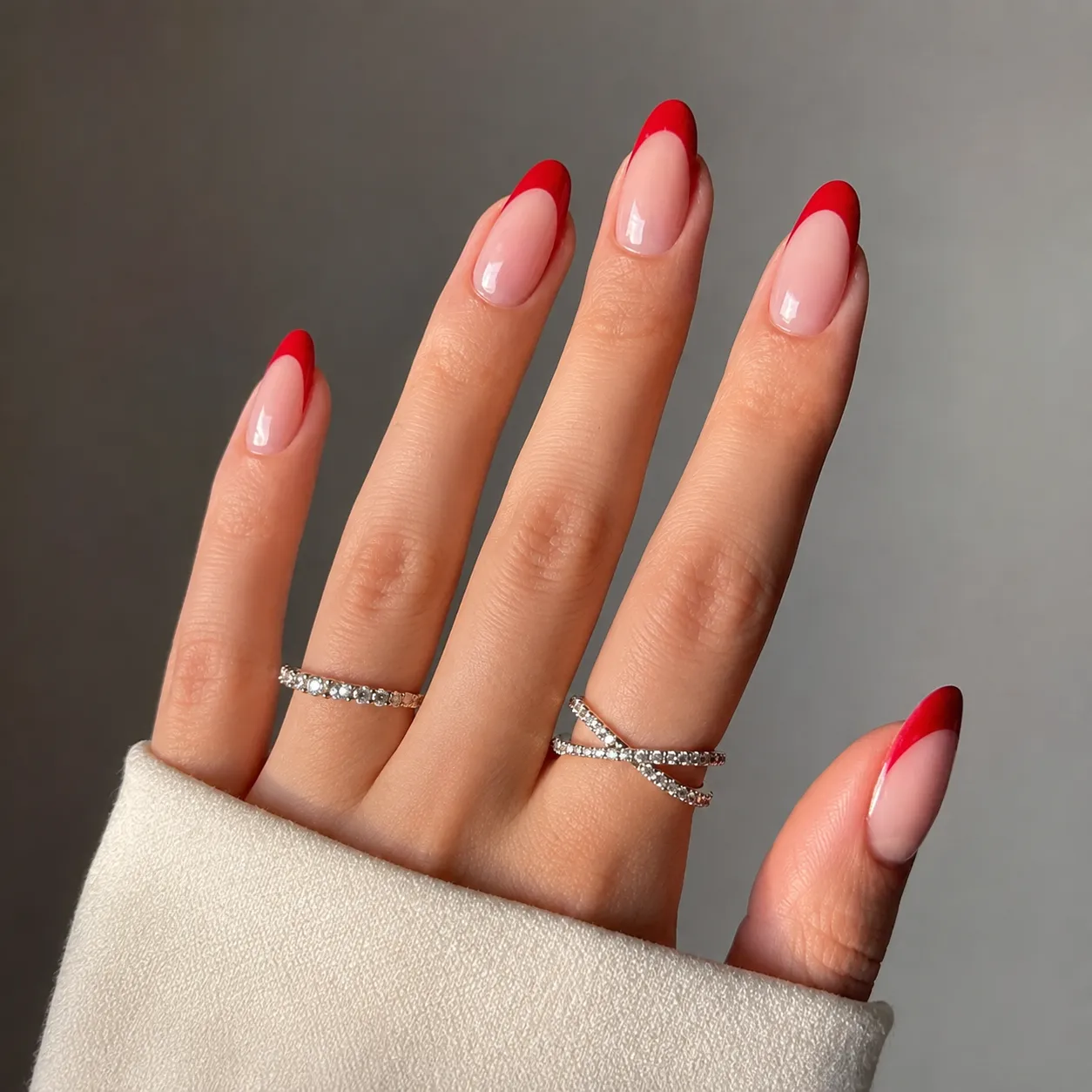Glossy classic cherry red French tip nails with a sheer pink base