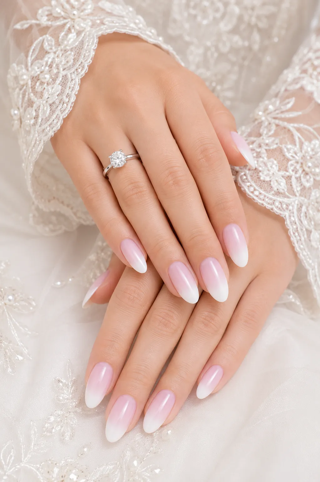 Cool blush Baby Boomer nails beside a bright white bridal dress and platinum ring