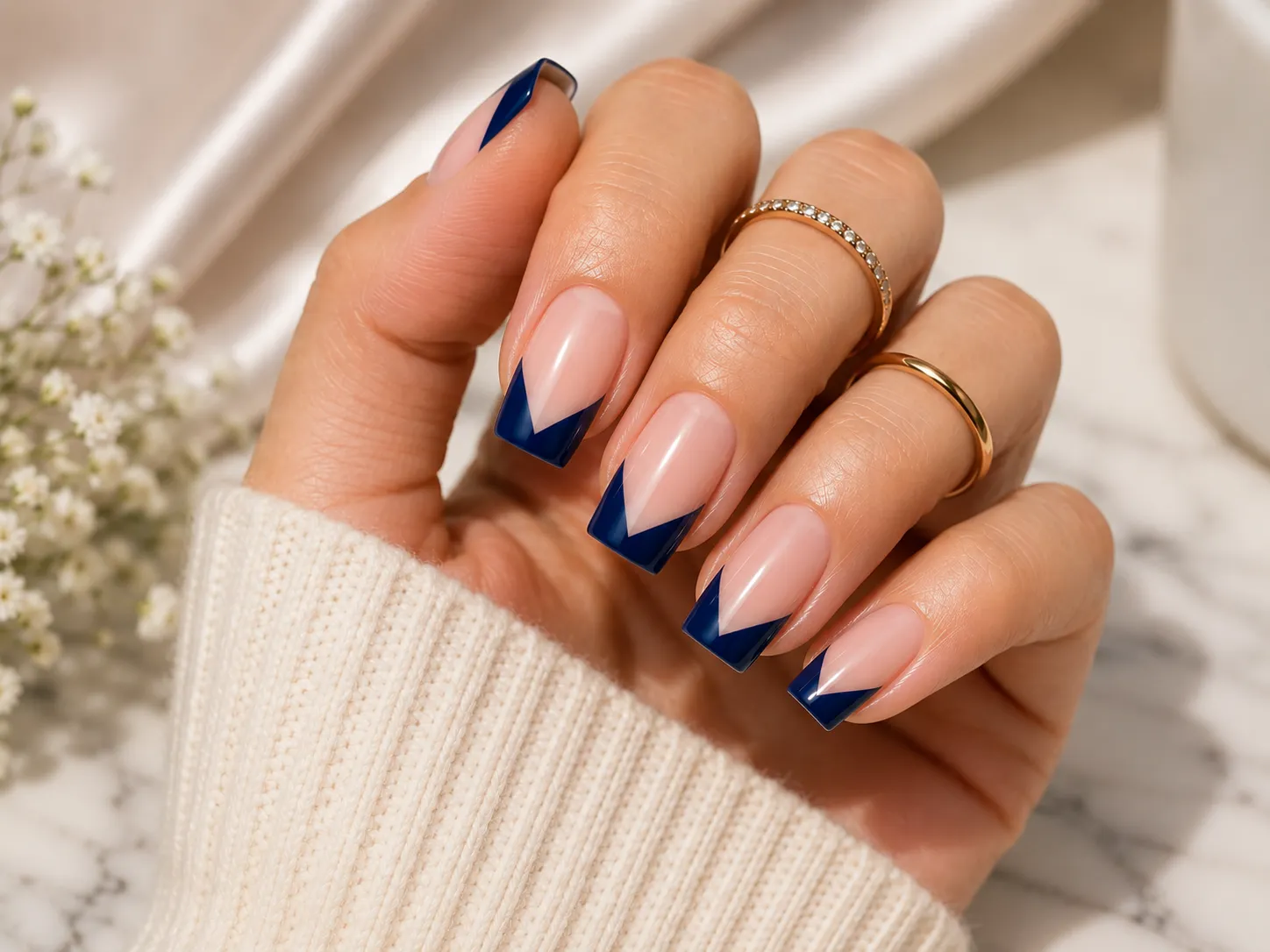 Deep navy V-cut French tip nails on a glossy sheer nude base