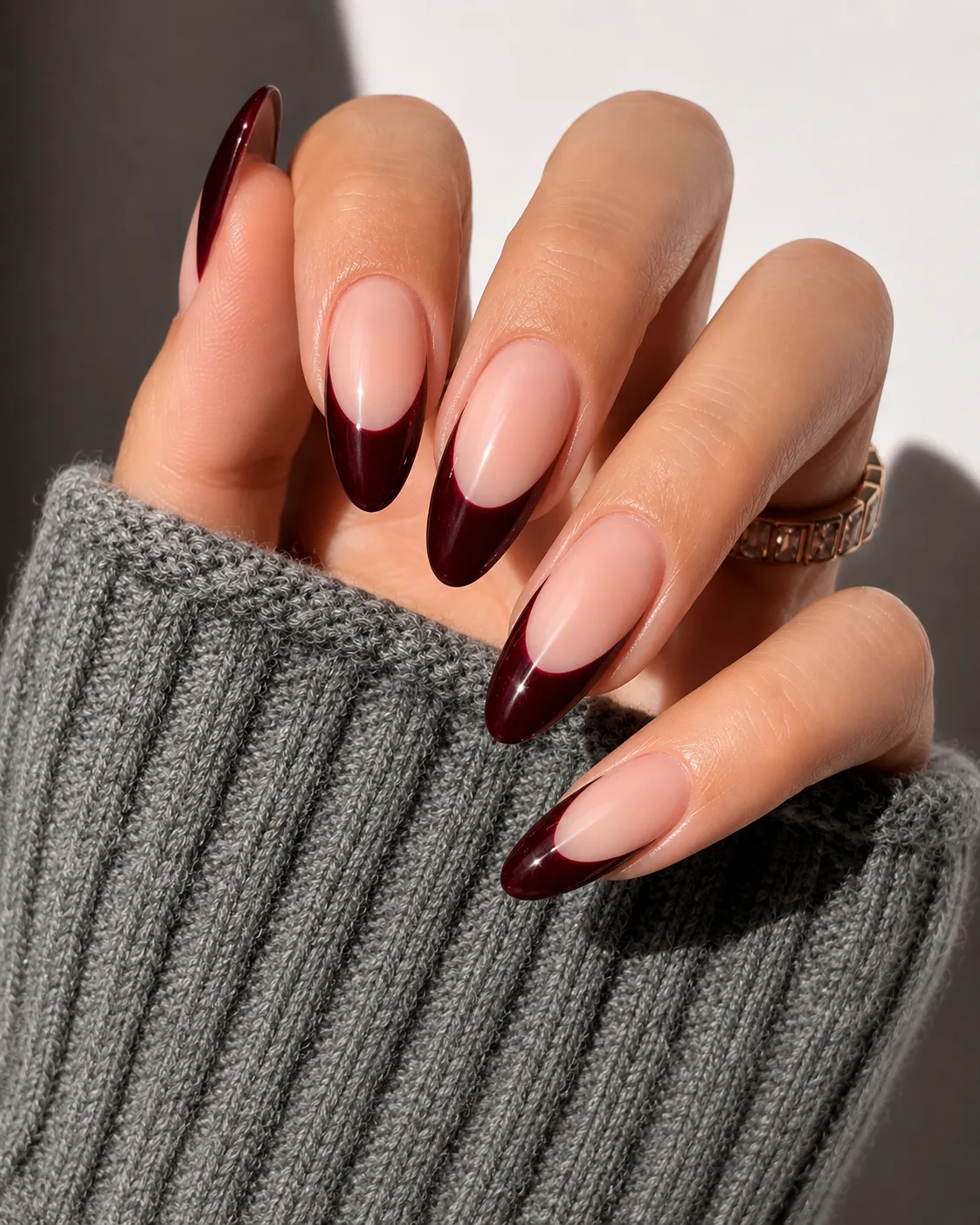 Dark oxblood French tip nails with a dramatic editorial finish