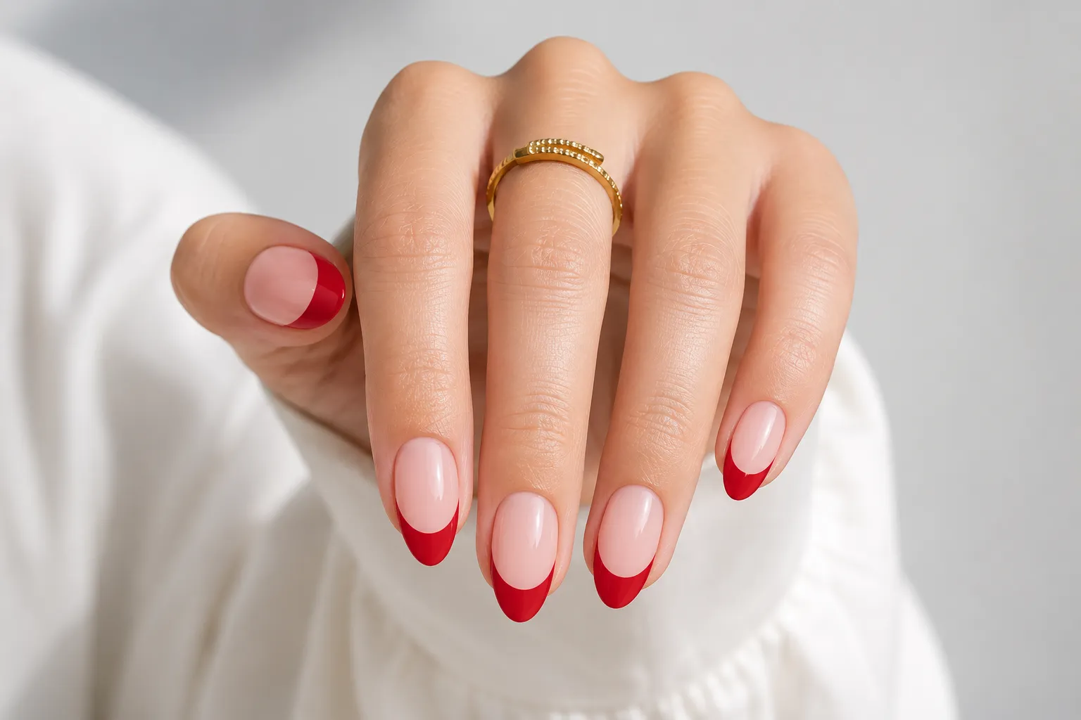 Red French tips on medium almond nails with a balanced smile line