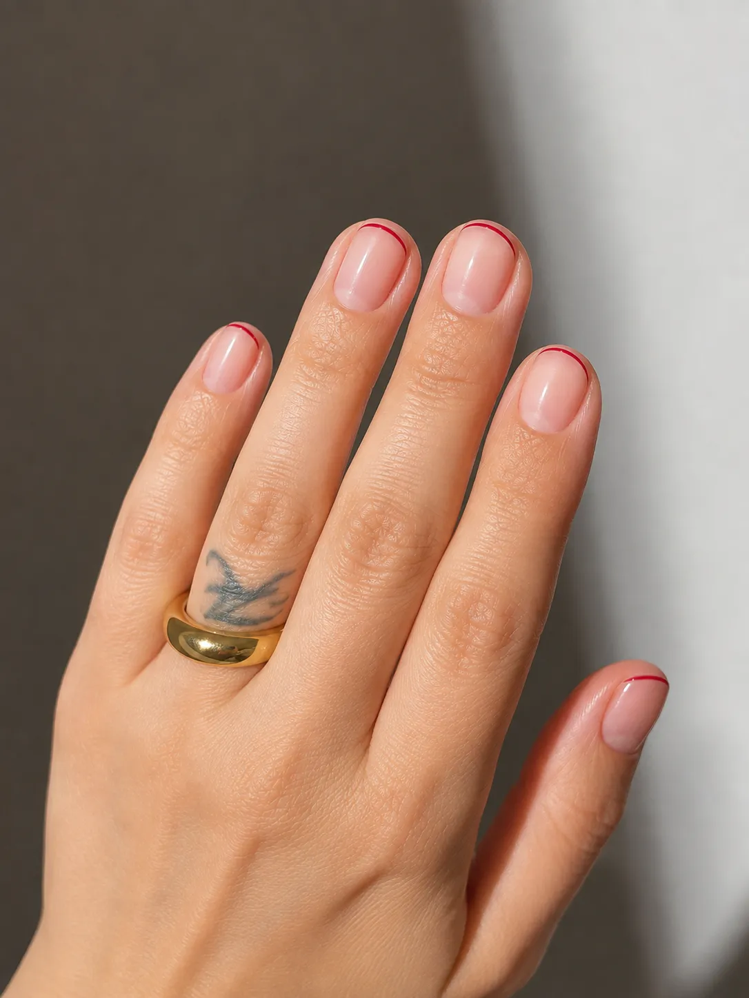 Thin red micro French tips on short round natural nails