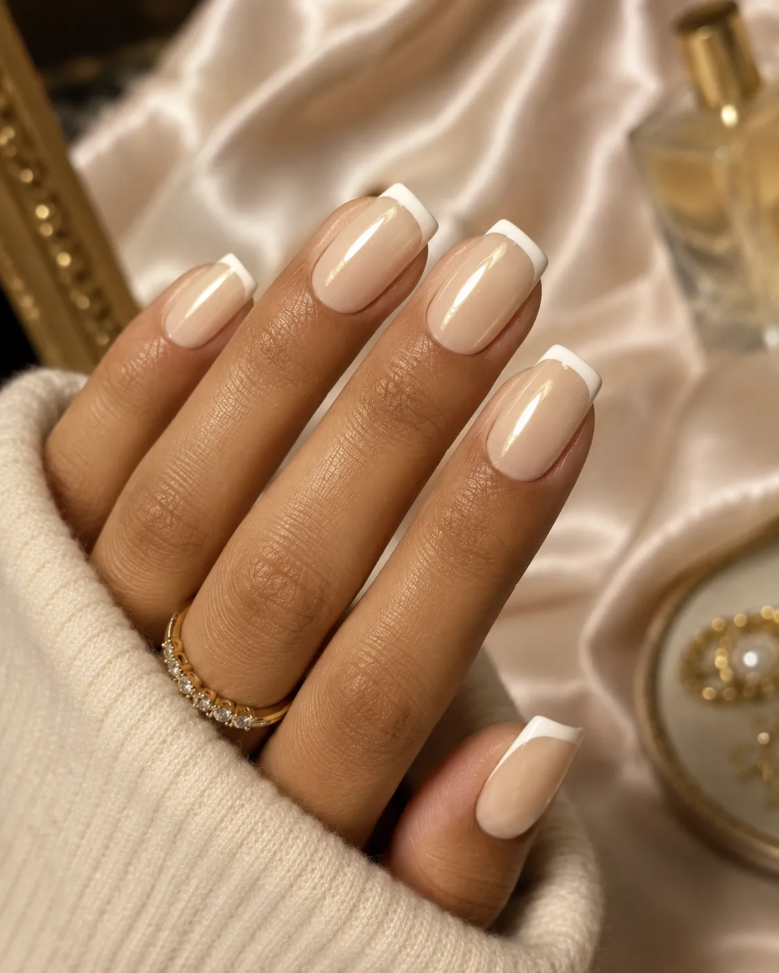 Warm vanilla glazed French tip nails on olive warm-toned skin
