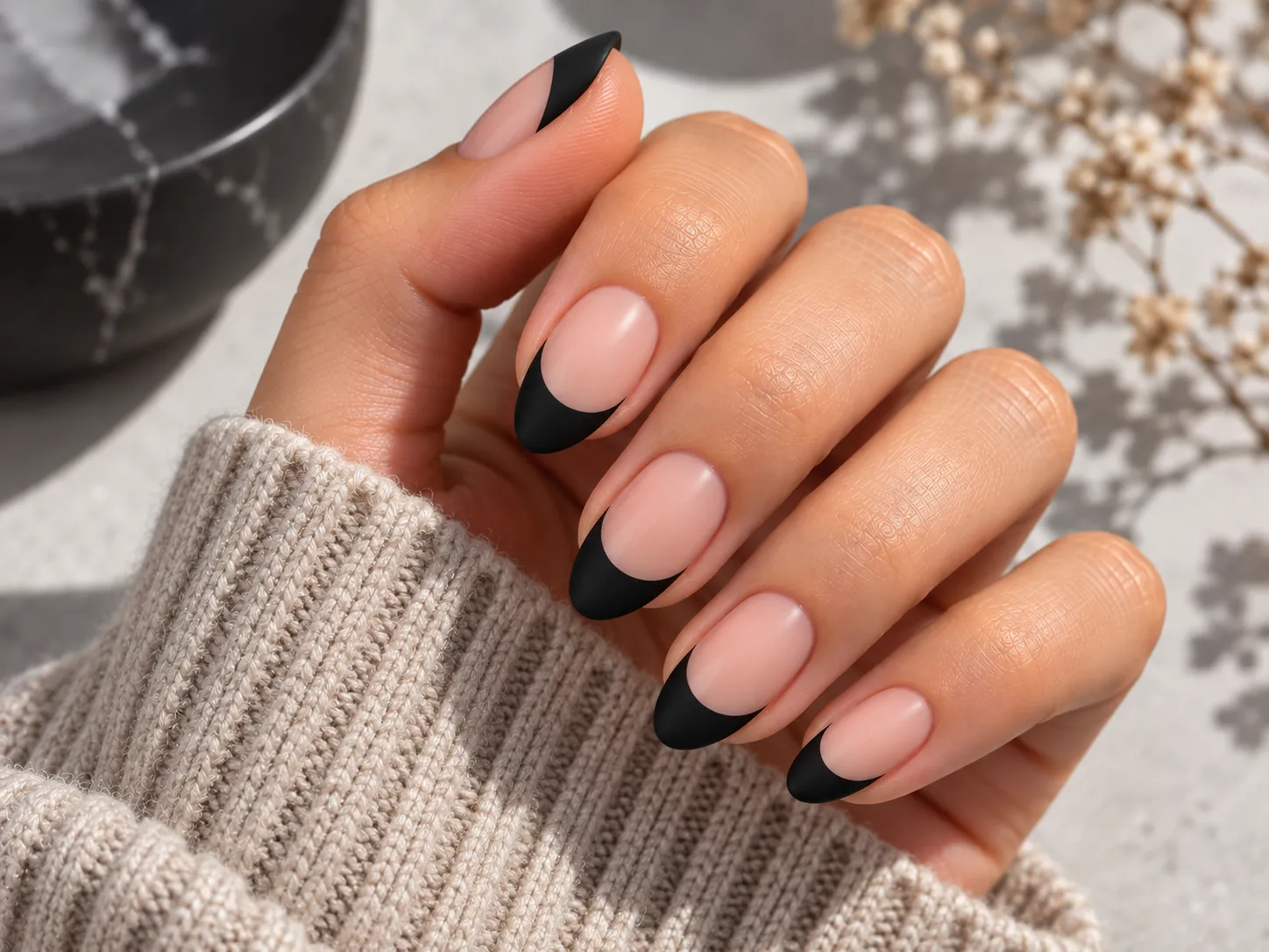 Matte black French tip nails over a sheer neutral base
