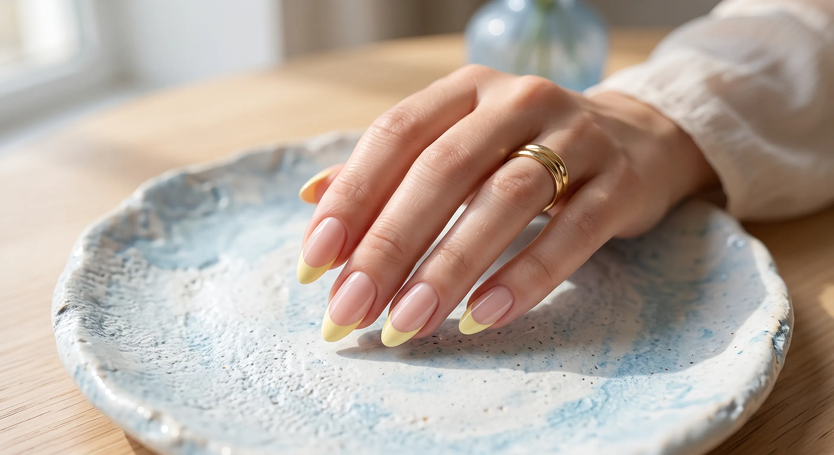 Pastel yellow French tip nails with pale soft-yellow smile lines